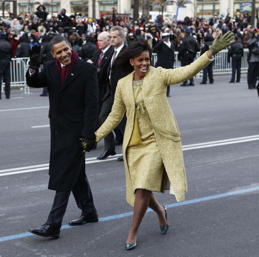 This Jan. 20, 2009, file photo shows President Barack Obama and first lady Michelle Obama, wearing a lemongrass-colored sheath dress and matching overcoat designed by Isabel Toledo as they walk the inaugural parade route in Washington, D.C.