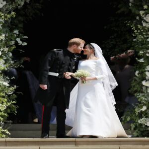 Prince Harry kisses his wife Meghan as they leave from the West Door of St George’s Chapel, Windsor Castle. | JANE BARLOW/AFP/Getty Images