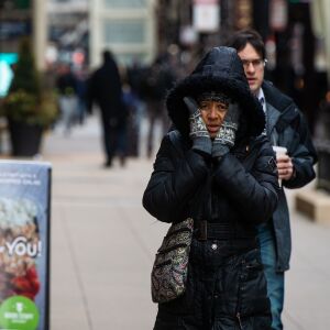 A woman covers her face with her gloved hands to stay warm, in The Loop, Friday afternoon, while temperatures were well below freezing, Friday, Jan. 25, 2019, in Chicago. | Tyler LaRiviere/Sun-Times