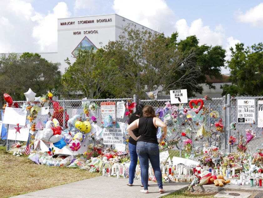 Mourners pay tribute at a memorial for the victims of the shooting at Marjory Stoneman Douglas High School on Sunday in Parkland, Fla. | David Santiago/Miami Herald via AP
