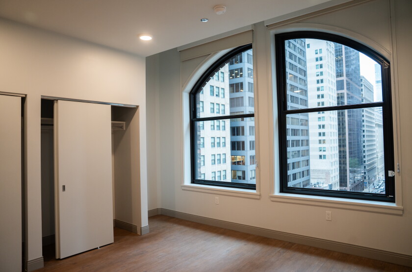 Inside the bedroom of a two-bedroom unit, with views of Downtown out a large window, at the Bellwether Residences in the Loop.