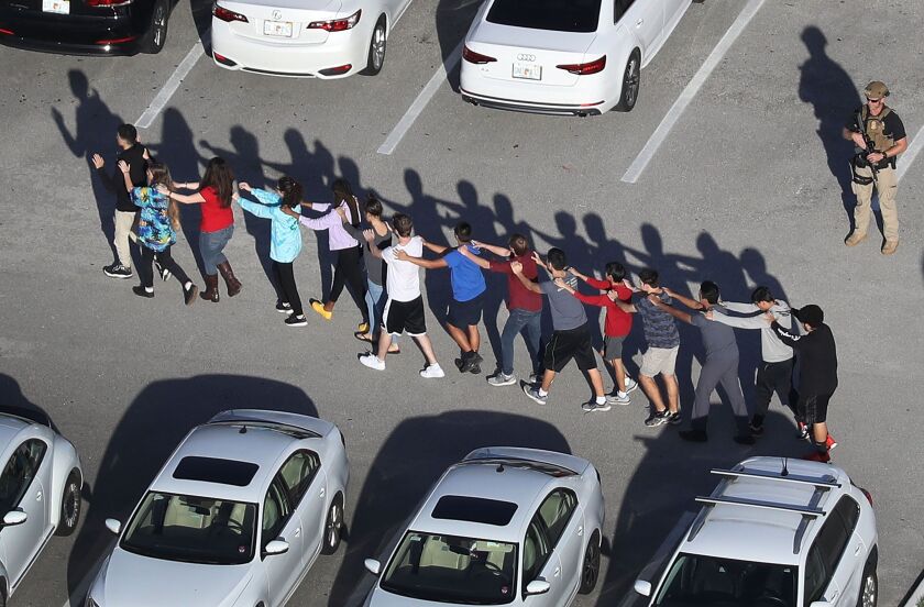People are brought out of Marjory Stoneman Douglas High School after a shooting at the school on Wednesday. | Joe Raedle/Getty Images