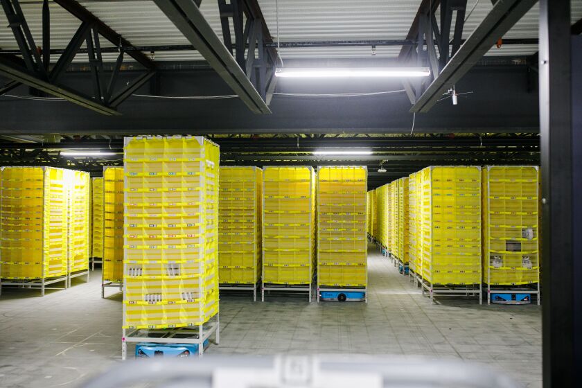A stack of totes moves on its own to a programmed destination, an example of new technology Amazon employs at its fulfillment center in Matteson.