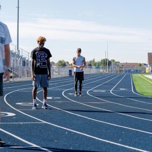 Plainfield South’s Niko Schultz sets his watch before running a speed drill with teammates Gabe King and Jayce James, timed by coach Marcus Norment during practice.