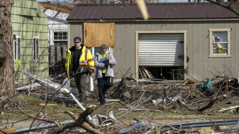 People survey the damage after a tornado ravaged a residential neighborhood in Aroma Park, Ill., in March 2026.