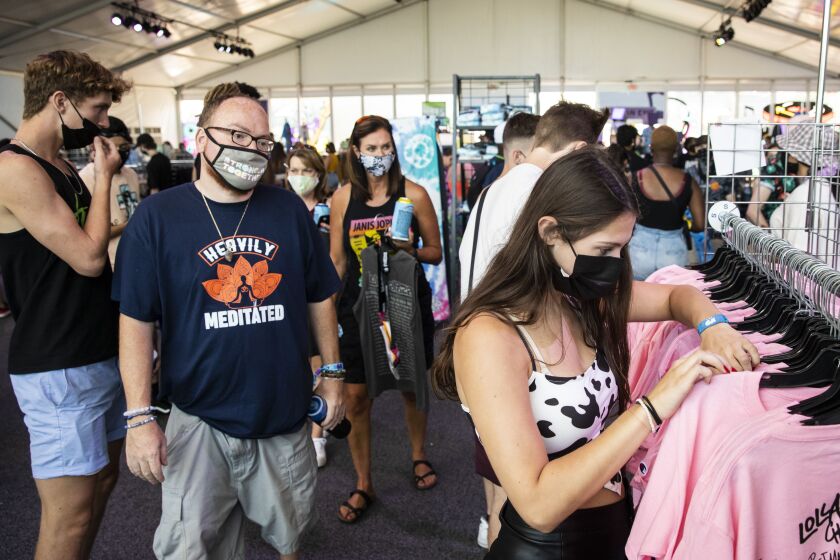 Following revised COVID safety protocols imposed by festival organizers on the previous night, festival-goers donned masks to shop for merchandise at the indoor Lolla Shop on Day 3 of Lollapalooza on Saturday in Grant Park. | Ashlee Rezin/Sun-Times