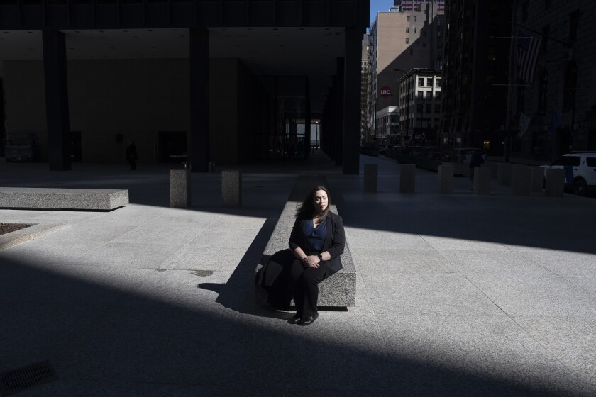 Vanessa Rollins, a former general engineer for the Internal Revenue Service, sits outside the John C. Kluczynski Federal Building in the Loop, where she used to work, Thursday, March 6, 2025. Rollins, who started working for the IRS in July 2024, was recently laid off. | Pat Nabong/Sun-Times