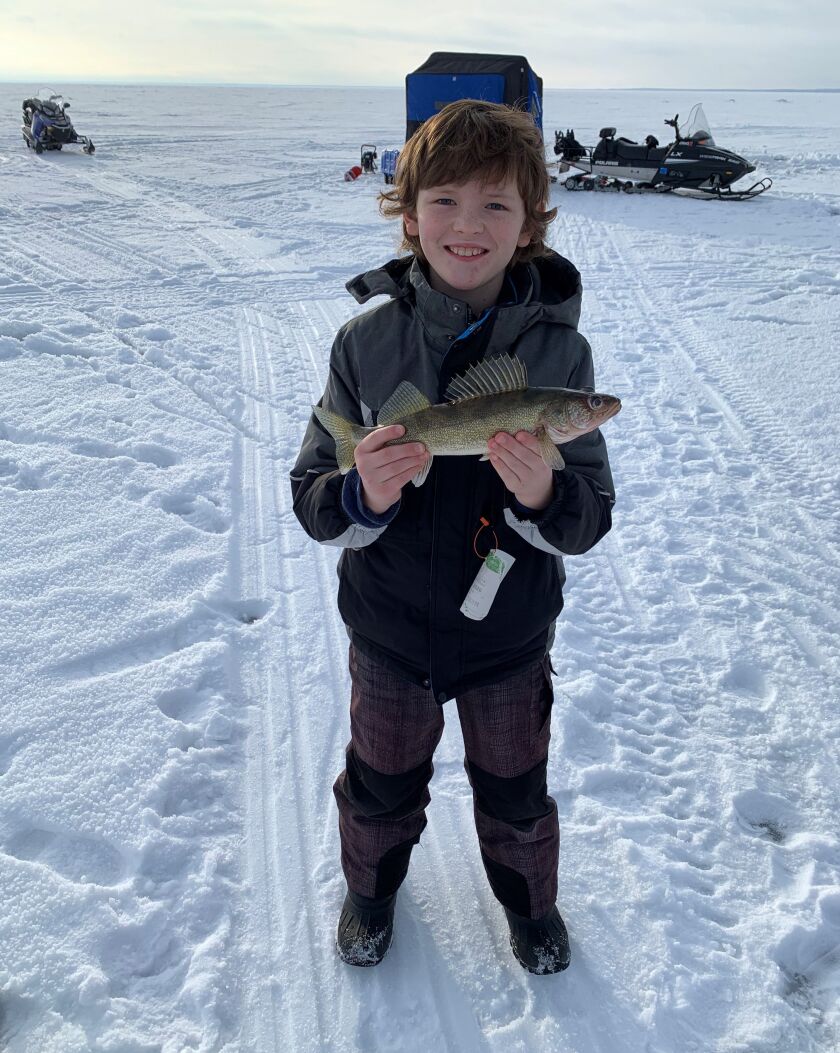 Iowan Liam with his first walleye, caught from Mille Lacs. Photo provided by McQuoids Inn