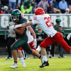 Glenbard West’s Nic Seifert (24) runs against Hinsdale Central’s defense.