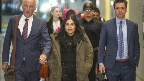 Marimar Martinez, green jacket, flanked by defense attorneys, walks towards reporters to speak in the lobby of the Dirksen Federal Courthouse, Thursday, Nov. 20, 2025.