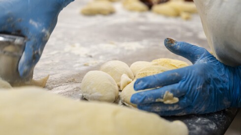 An employee cuts dough to make paczki at Polish Paczki Cafe in Norwood Park, Saturday, Jan. 31, 2026. | Pat Nabong/Sun-Times