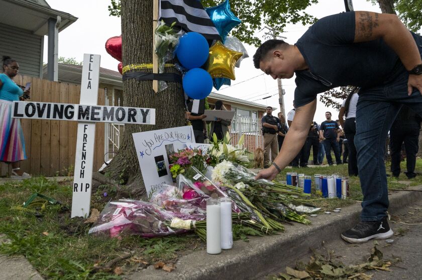 A police officer leaves flowers at the memorial erected to honor Officer Ella French. A vigil was held at the memorial Monday, Aug. 9, 2021.