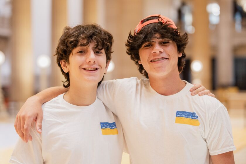 Michael Kotcher, 15, left, and Ryder Shiffman, 16, right, stand together Thursday at the Wintrust’s Grand Banking Hall in the Loop.