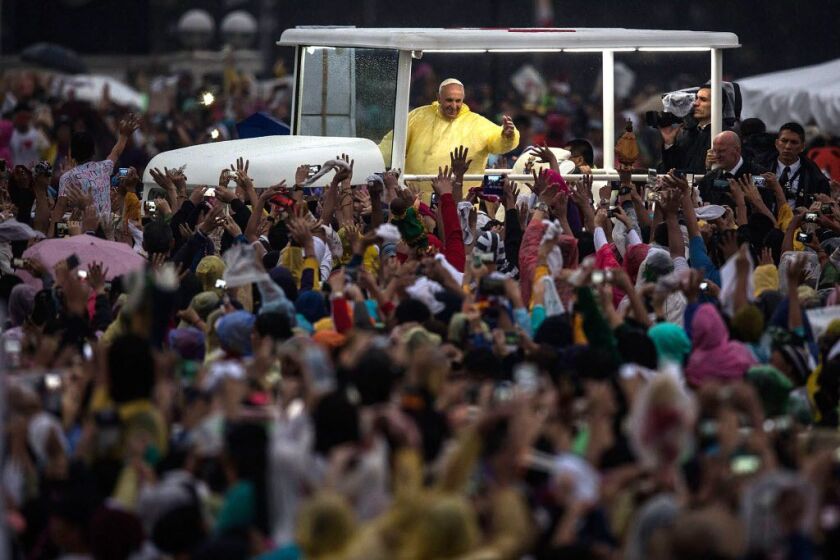 Pope Francis waves to the crowd after conducting mass at the Rizal Park on Sunday in Manila, Philippines. | Lam Yik Fei/Getty Images