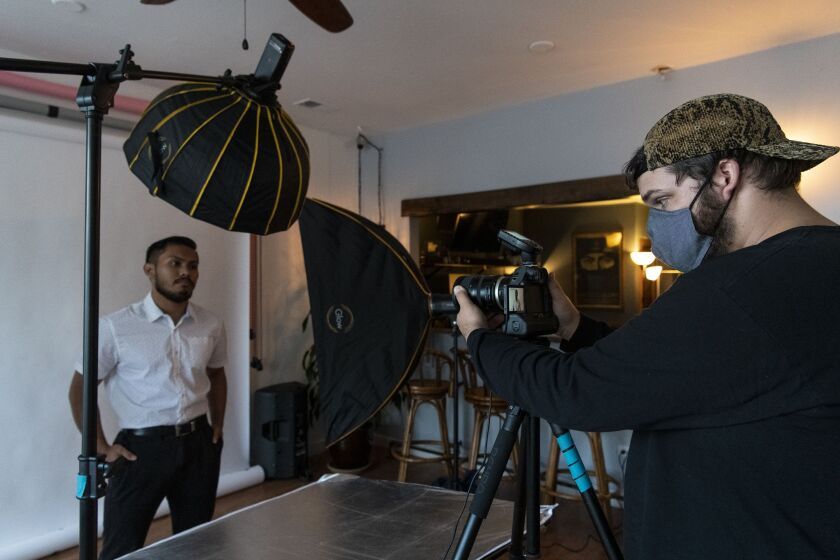 Harry Aaron frames a photo of Anthony Ramos during Aaron’s pay-what-you-can professional photoshoot for unemployed workers at the Logan Square Creative Studio on Friday.