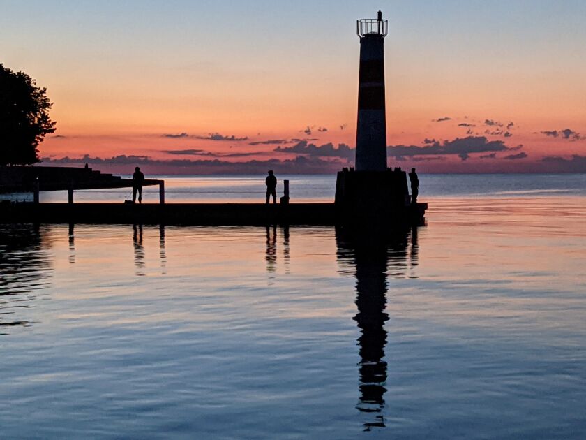 File photo of anglers, trying for early Chinook, on the east jetty at the mouth of Montrose Harbor silhouetted in the pre-dawn half light. Credit: Dale Bowman