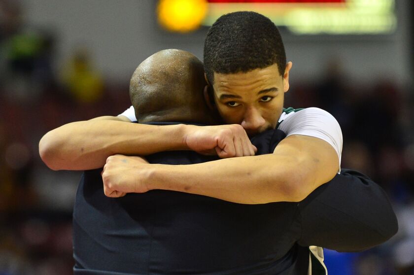 Billy Garrett Jr. hugs Morgan Park coach Nick Irvin.