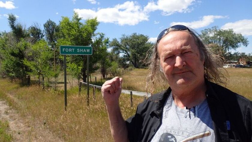 Chris Shaw, better known as Jolly Roger, has raised over $40,000 for dental work. Shaw is standing in front of a road marker for Fort Shaw.
