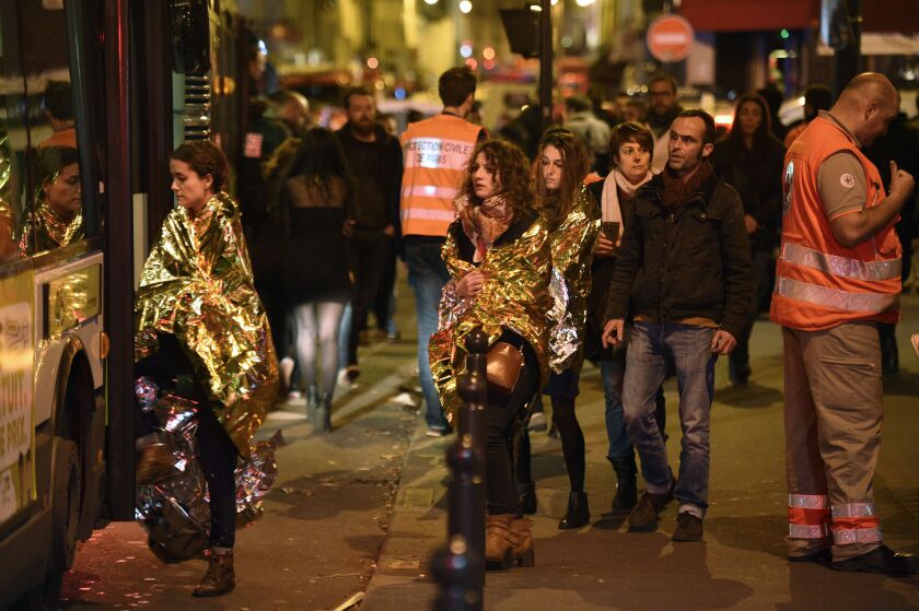 People are evacuated by bus, near the Bataclan concert hall in central Paris. | Martin Bureau/AFP/Getty Images