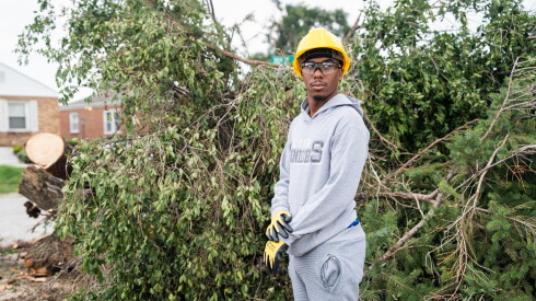 Miles Lewis, who is volunteering to clear trees, in front of downed trees on 20th Street and Van Buren Street in Gary, Ind., Wednesday, Aug. 26, 2026.