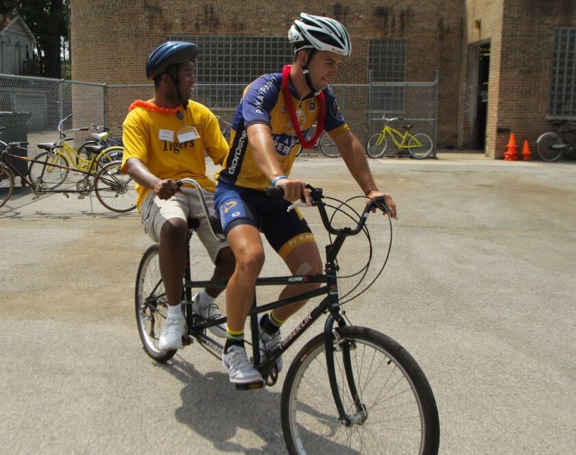 Daniel Gramer, from the Ability Experience, shares a tandem with Marcus Womack, of Envision Unlimited, on Wednesday at a partyat the Envision Unlimited Westtown Center. | Leslie Adkins/For the Sun-Times