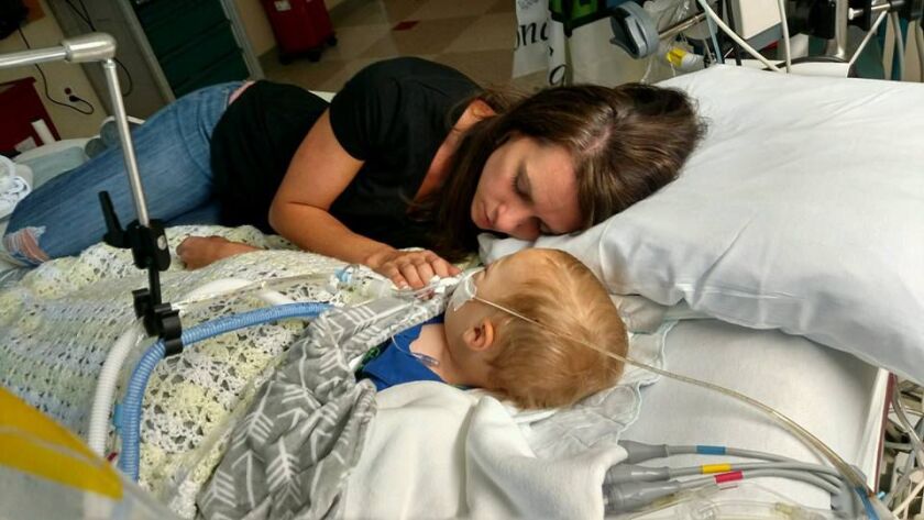 Jenny Bennett is lying next to her 18-month-old son, Jackson, on a hospital bed after his drowning accident. He did not survive.