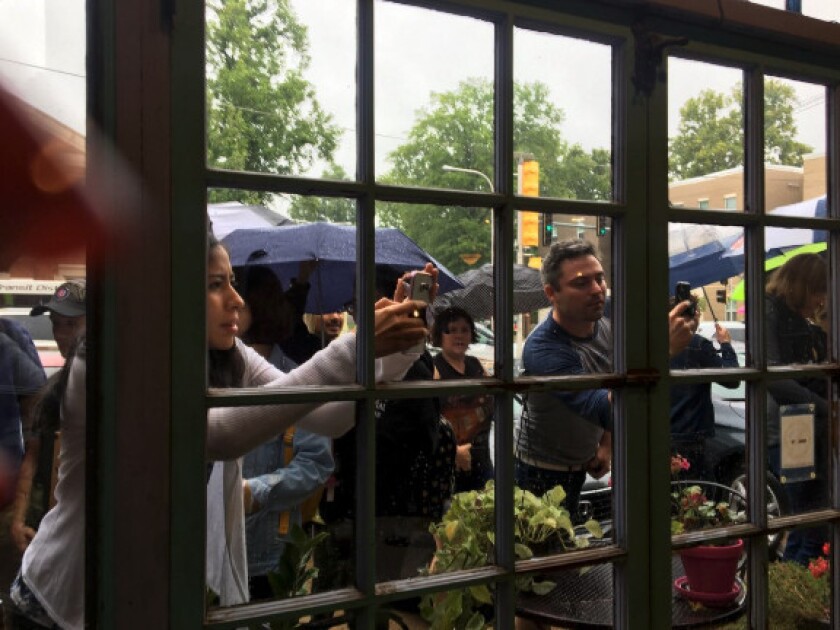 Students peer inside an Urbana coffeeshop Friday where Barack Obama appeared with Democratic gubernatorial candidate J.B. Pritzker. | Tina Sfondeles/Sun-Times