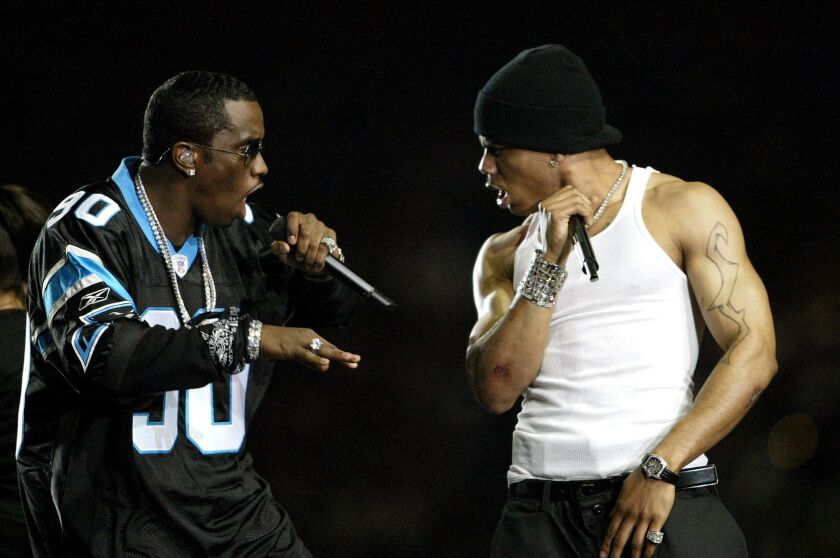Sean “P. Diddy” Combs (L) and Nelly (R) perform during the halftime show at Super Bowl XXXVIII between the New England Patriots and the Carolina Panthers at Reliant Stadium on February 1, 2004 in Houston, Texas. | Elsa/Getty Images
