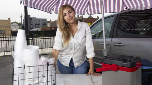 Laura Murillo stands beside her van, folding table, coolers and umbrella, items she used while selling tamales in the Back of the Yards neighborhood before she was taken into immigration custody nearly a year ago.