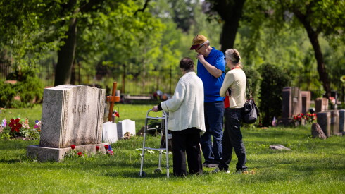 From left: Arlene Kucaba, Kathy Kucaba and Bob Kucaba visit their husband and father’s grave at Bohemian National Cemetery in North Park to commemorate Memorial Day, Sunday, May 24, 2026. Anton V. Kucaba was a World War II veteran and a Bronze Star recipient who died in 2018.