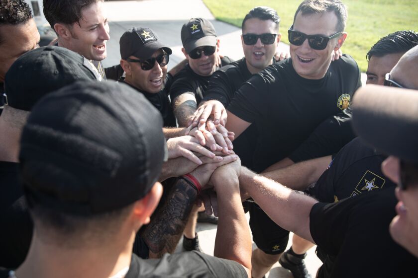 Members of the U.S. Army Golden Knights parachute team put their hands together before donning their jumpsuits for practice jumps Friday in preparation for the weekend’s 2023 Chicago Air and Water Show.