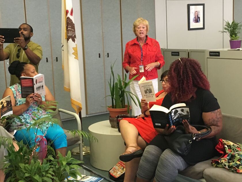 A worker at the Thompson Center approached the Chicago teachers who were silently reading in the lobby and asked them to “keep it down” for employees in the nearby Comptroller’s office. | Jacob Wittich/Sun-Times