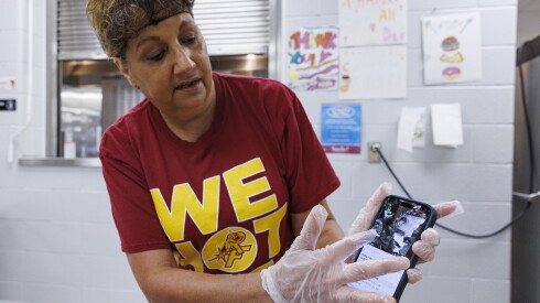 Kathy Doeing shows off a video of damage at her home on Friday.