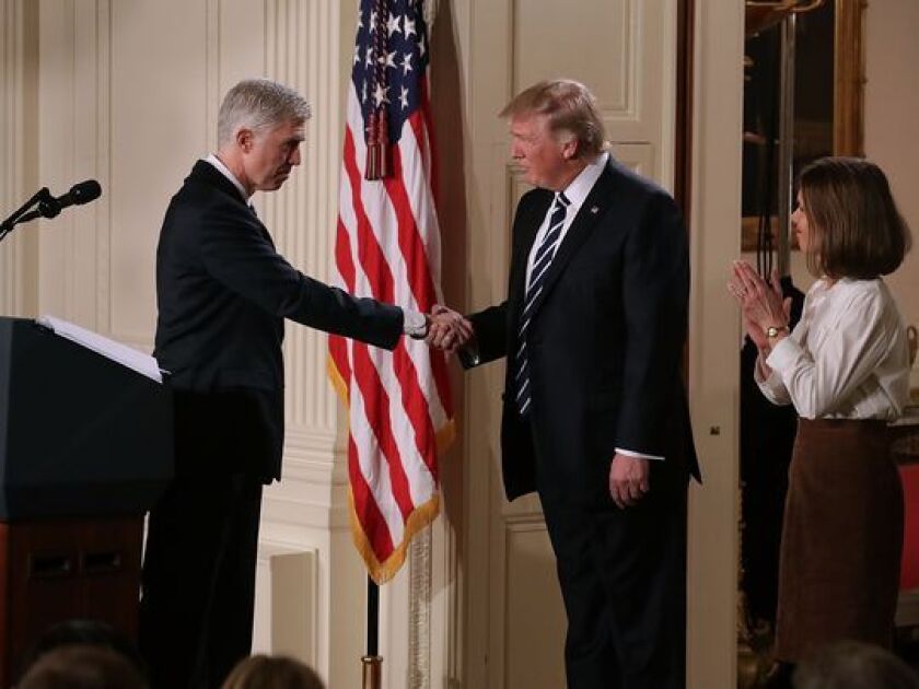 President Donald Trump shakes hands with Neil Gorsuch, accompanied by his wife, Marie Louise Gorsuch, after nominating him to the Supreme Court on Jan. 31. | Getty Images