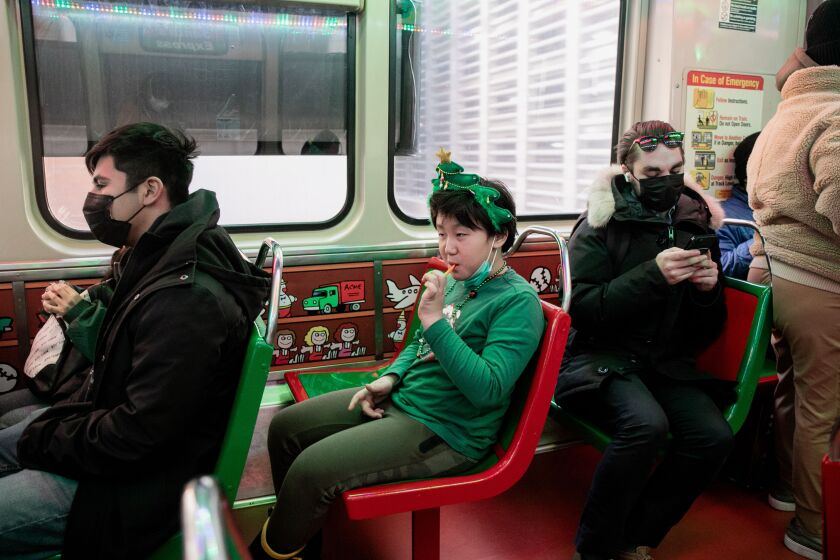 Joey Park eats a candy cane while aboard the CTA Holiday Train around the Loop Monday afternoon, Dec. 20, 2021.