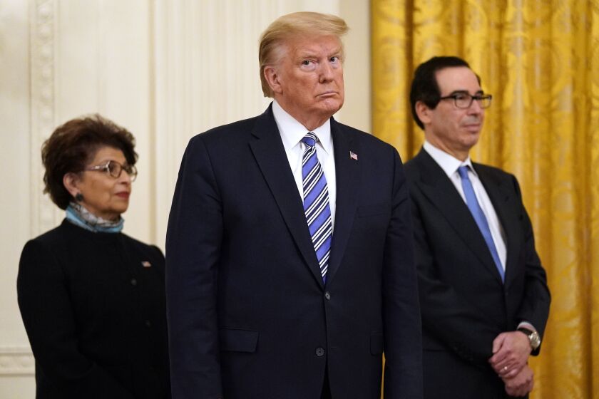 President Donald Trump, along with Jovita Carranza, administrator of the Small Business Administration, and Treasury Secretary Steven Mnuchin.