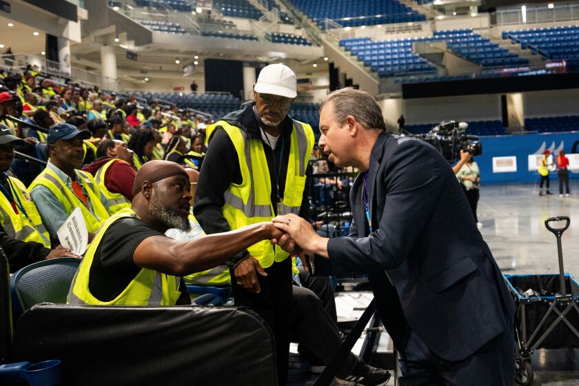 Chicago Public Schools CEO Pedro Martinez shakes hands with Safe Passage worker Ernest Deforneau, who works in the Bronzeville neighborhood with the Alliance for Community Peace, during a celebration of Safe Passage workers at Wintrust Arena in the South Loop, Tuesday, Aug. 15, 2023.