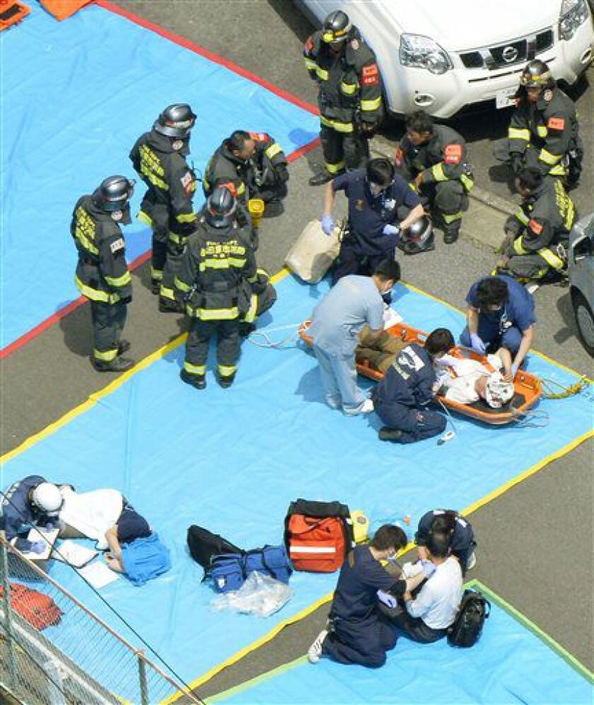 Passengers receive treatment in Odawara, west of Tokyo, after a passenger tried to set himself or herself on fire. | Kyodo News via AP