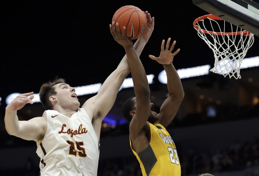 Loyola’s Cameron Krutwig, left, knocks the ball away from Valparaiso’s Mileek McMillan.