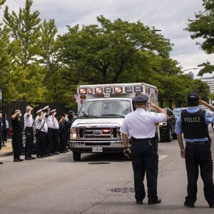 Officers salute outside the Cook County medical examiner’s office on the afternoon of Tuesday, July 28, 2020 as an ambulance passes containing the body of Deputy Chief Dion Boyd, who was found dead in his office that morning of an apparent suicide.