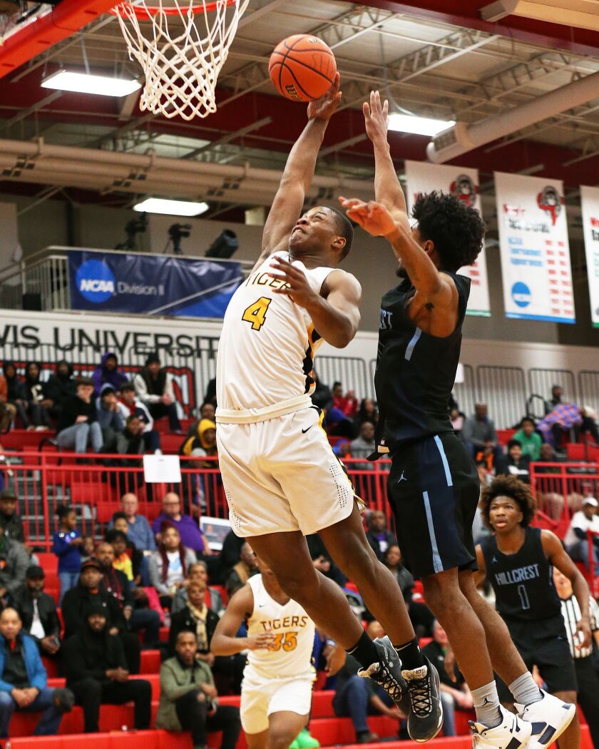 Joliet West’s Trent Howland (4) grabs a rebound and goes up strong for a dunk against Hillcrest.