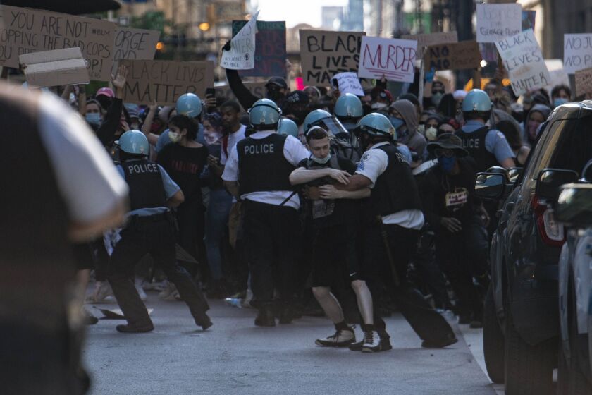 Chicago police and protesters scuffle near Daley Plaza, Saturday, May 30, 2020. 