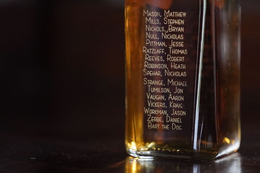 The names of servicemen who died when their Chinook helicopter was shot down in 2011 in Afghanistan are seen on a liquor bottle.