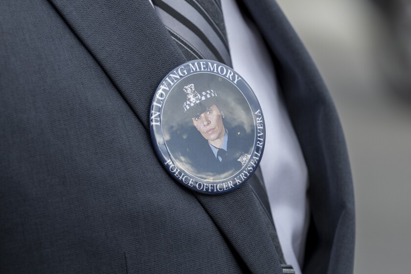 A Chicago police officer wears a pin commemorating officer Krystal Rivera during a visitation at Montclair-Lucania Funeral Home on the Northwest Side, Tuesday, June 24, 2025, in Chicago.