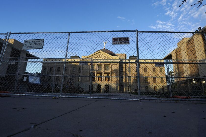 Two layers of security fencing is shown encircling the Arizona Capitol Saturday, Jan. 16, 2021, in Phoenix.