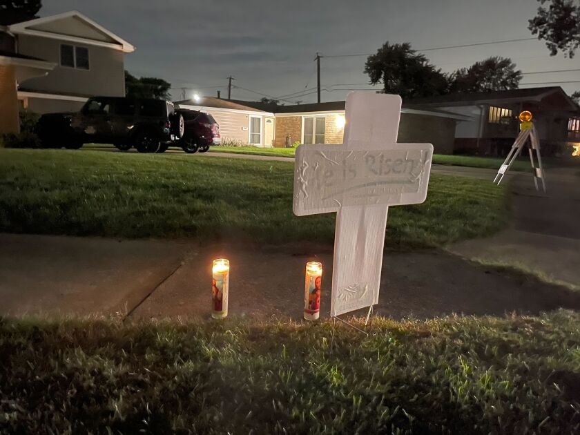 A cross and two candles outside a home Friday in the 5500 block of Ann Marie Lane in Oak Forest.