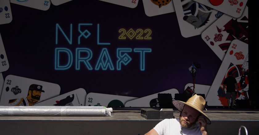 A worker helps erect a red carpet and stage in front of the Bellagio Hotel and Casino during setup for this year’s NFL Draft.