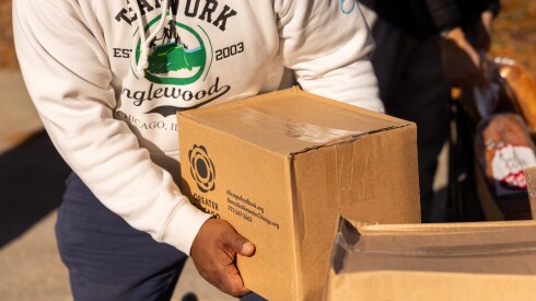 A steward grabs a box of nonperishables during an emergency food giveaway organized by Grow Greater Englewood and the Englewood Food Sovereignty Network in partnership with the Greater Chicago Food Depository on the South Side, Saturday, Nov. 15, 2025. | Candace Dane Chambers/Sun-Times.