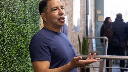 Victor Vazquez, co-owner of Victor Mauricio Hair Salon, speaks with attendees of the Illinois Hispanic Chamber of Commerce's "shop local" tour in Brighton Park.