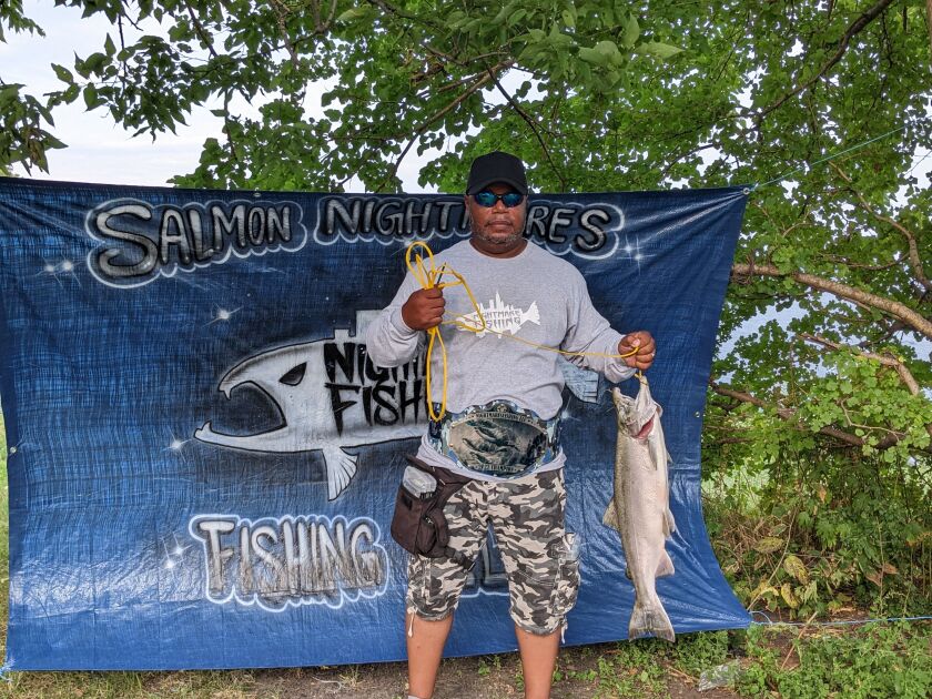 Larry Powell sports his second championship belt in three years and hoists the winning salmon Saturday at Jackson Park during the Slamming Salmon Nightmare Fishing LLC Tournament. Credit: Dale Bowman